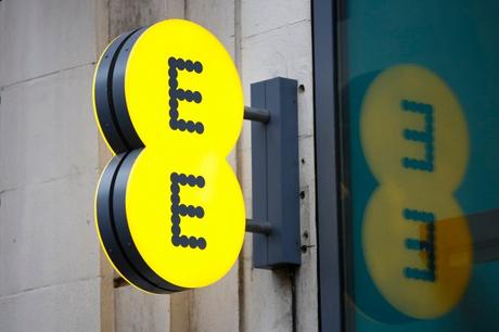 Un logo EE illuminé se reflète dans la fenêtre d'un magasin de téléphonie mobile EE, exploité par Orange SA et Deutsche Telekom AG, à Londres, au Royaume-Uni, le jeudi 5 février 2015. BT Group Plc a accepté d'acheter l'opérateur de téléphonie mobile britannique EE Ltd pour 12,5 milliards de livres (19 milliards de dollars) pour créer un géant du sans fil et du haut débit destiné à bouleverser l'industrie des télécommunications du pays.  Photographe : Simon Dawson/Bloomberg via Getty Images