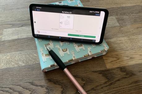 Un téléphone est posé sur une table, montrant un programme d'art avec un stylet.