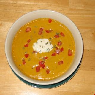 Sweet potato soup warmly spiced and beautifully presented. Use creme fraiche if available in place of the sour cream.