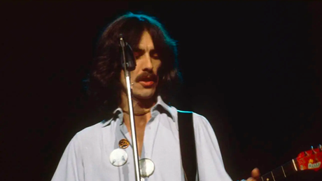 En tant que vétéran de la musique, George Harrison n’avait pas besoin que son ego soit stimulé par les tournées. George Harrison souriant sans besoin de tournées