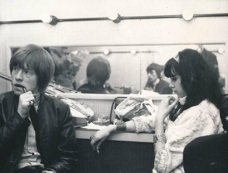 Brian Jones assis dans une cabine d'essayage à côté d'une femme aux cheveux noirs et à la frange