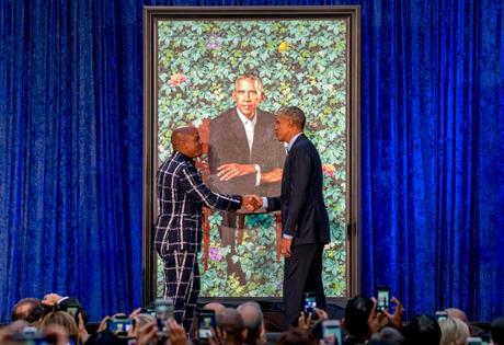 L'ancien président Barack Obama, à droite, et l'artiste Kehinde Wiley, à gauche, se serrent la main en dévoilant le portrait officiel d'Obama à la Smithsonian's National Portrait Gallery, le lundi 12 février 2018, à Washington.