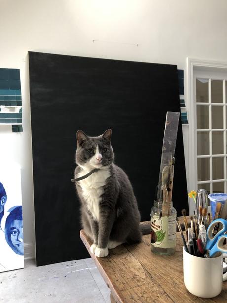 Dans son studio, l’artiste Maya Varadaraj peint d’immenses portraits sur une bande originale de films “Harry Potter”, son chat à ses côtés Benedict Arnold Pattington, compagnon d'atelier de l'artiste. Avec l'aimable autorisation de l'artiste.