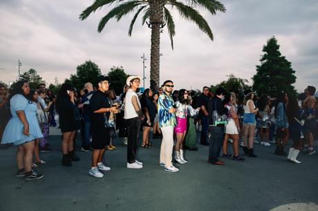 Les gens font la queue près d’un palmier.